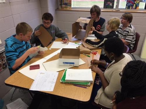 students working on cardboard designs 